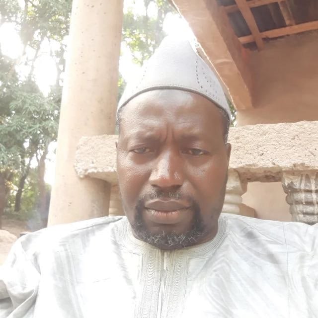 Portrait du Professeur Sayon en tenue traditionnelle blanche